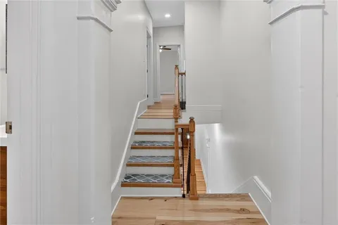 a view of a hallway with wooden floor and staircase