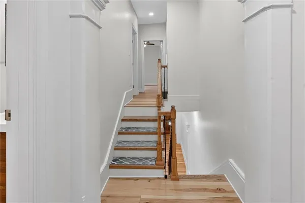 a view of a hallway with wooden floor and staircase