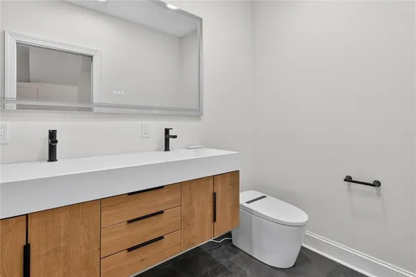 a bathroom with a toilet a sink and mirror