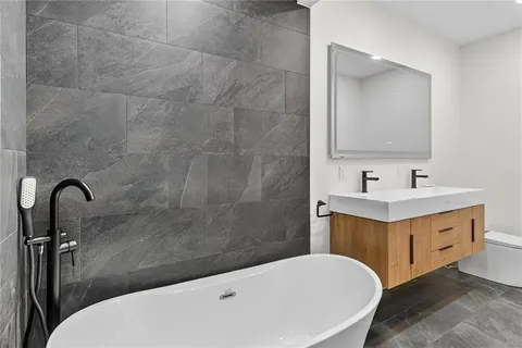 a bathroom with a sink a toilet and a mirror