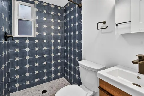 a white toilet sitting next to a bathroom sink