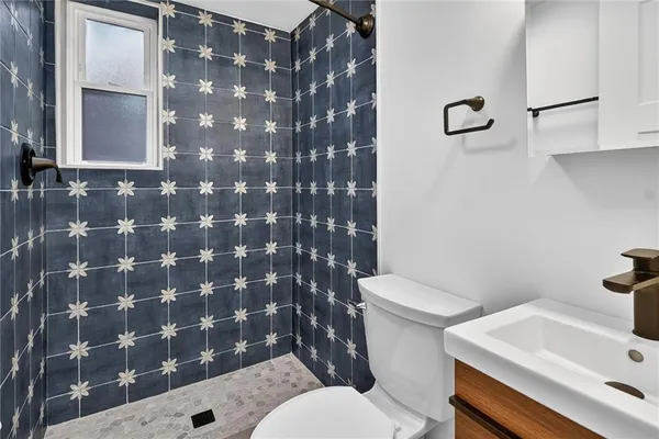 a white toilet sitting next to a bathroom sink