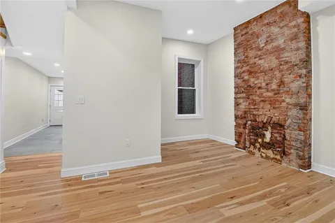 a view of empty room with wooden floor and window