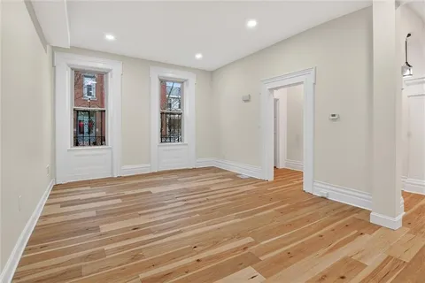 a view of empty room with wooden floor