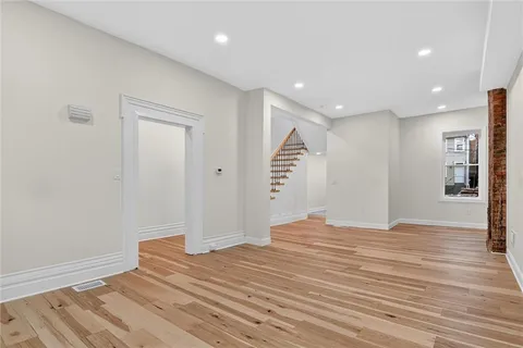 a view of empty room with wooden floor
