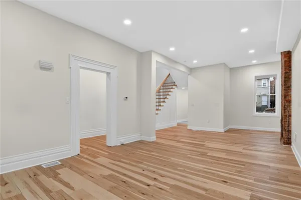 a view of empty room with wooden floor