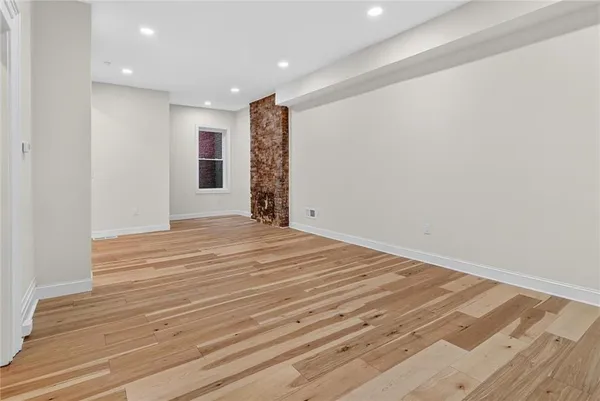 a view of empty room with wooden floor