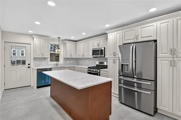 a kitchen with stainless steel appliances granite countertop a refrigerator stove microwave and sink