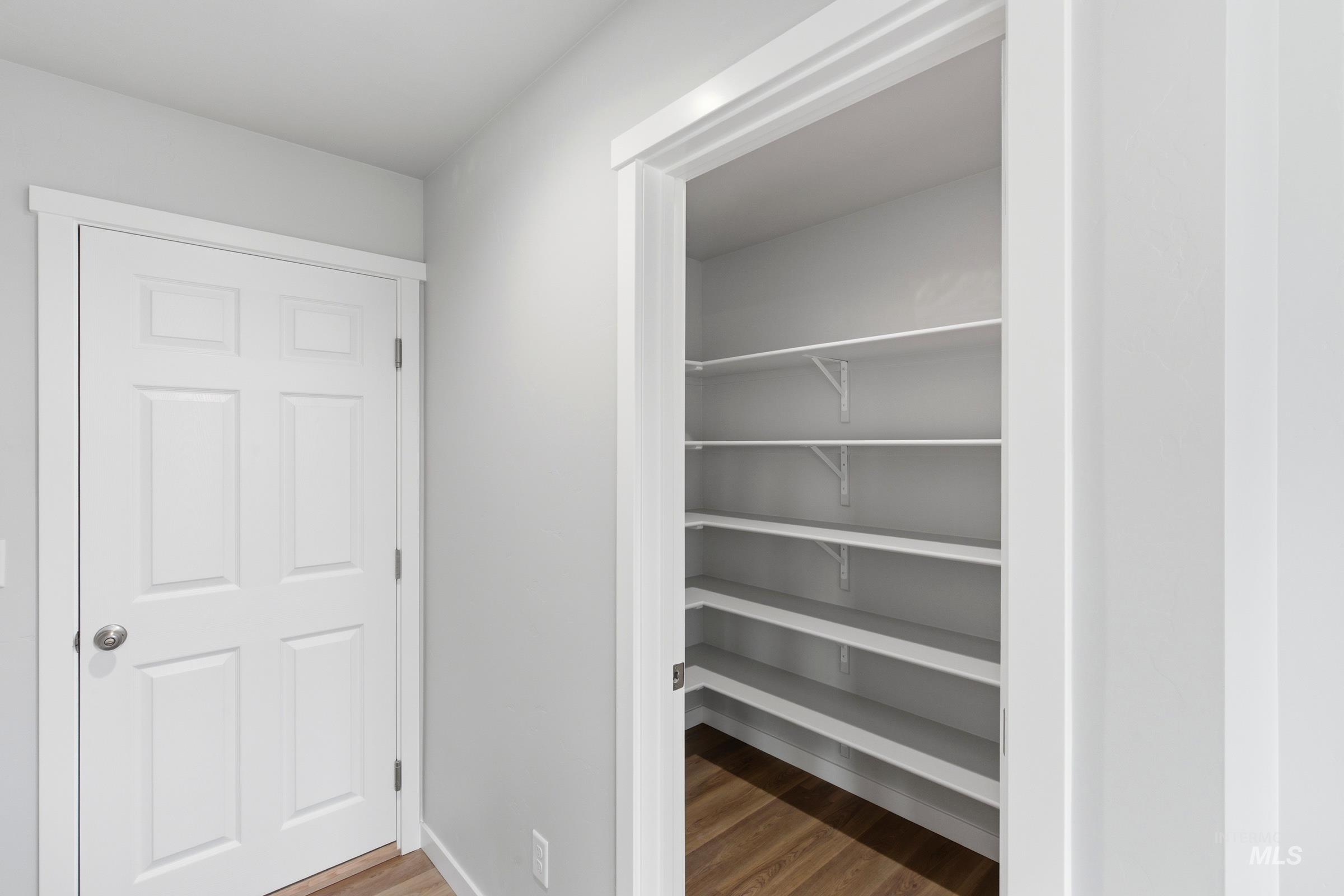 16558 Dunning Way Caldwell, ID 83607 - Photo 11 of 35 Spacious pantry featuring multiple tiers of shelving and wood-finish flooring