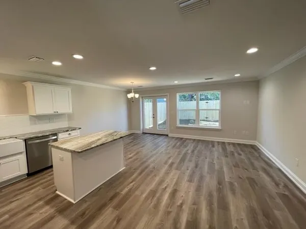 a kitchen with stainless steel appliances granite countertop a stove and a wooden floors