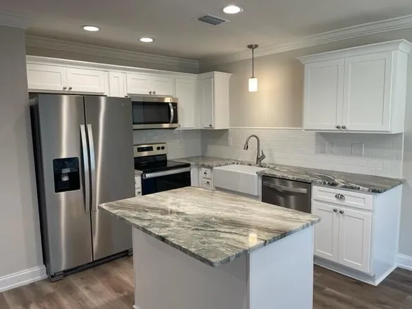 a kitchen with stainless steel appliances granite countertop a sink stove and refrigerator