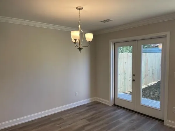 a view of a room with wooden floor chandelier and glass door