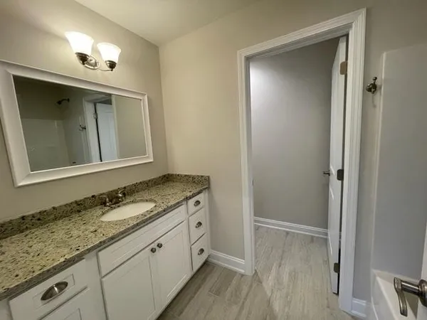 a bathroom with a granite countertop sink mirror and vanity
