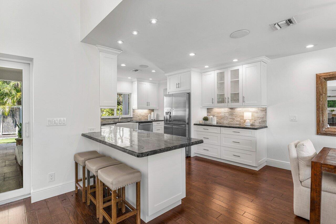 6130 Ridge Lane Ocean Ridge, FL 33435 - Photo 11 of 33 a kitchen with stainless steel appliances granite countertop a sink stove and wooden floor