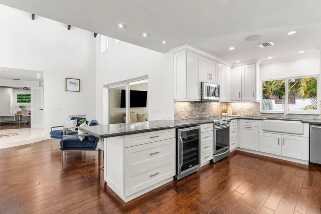 a kitchen with stainless steel appliances granite countertop a sink stove and wooden floor