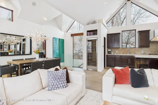 a living room with furniture kitchen view and a window