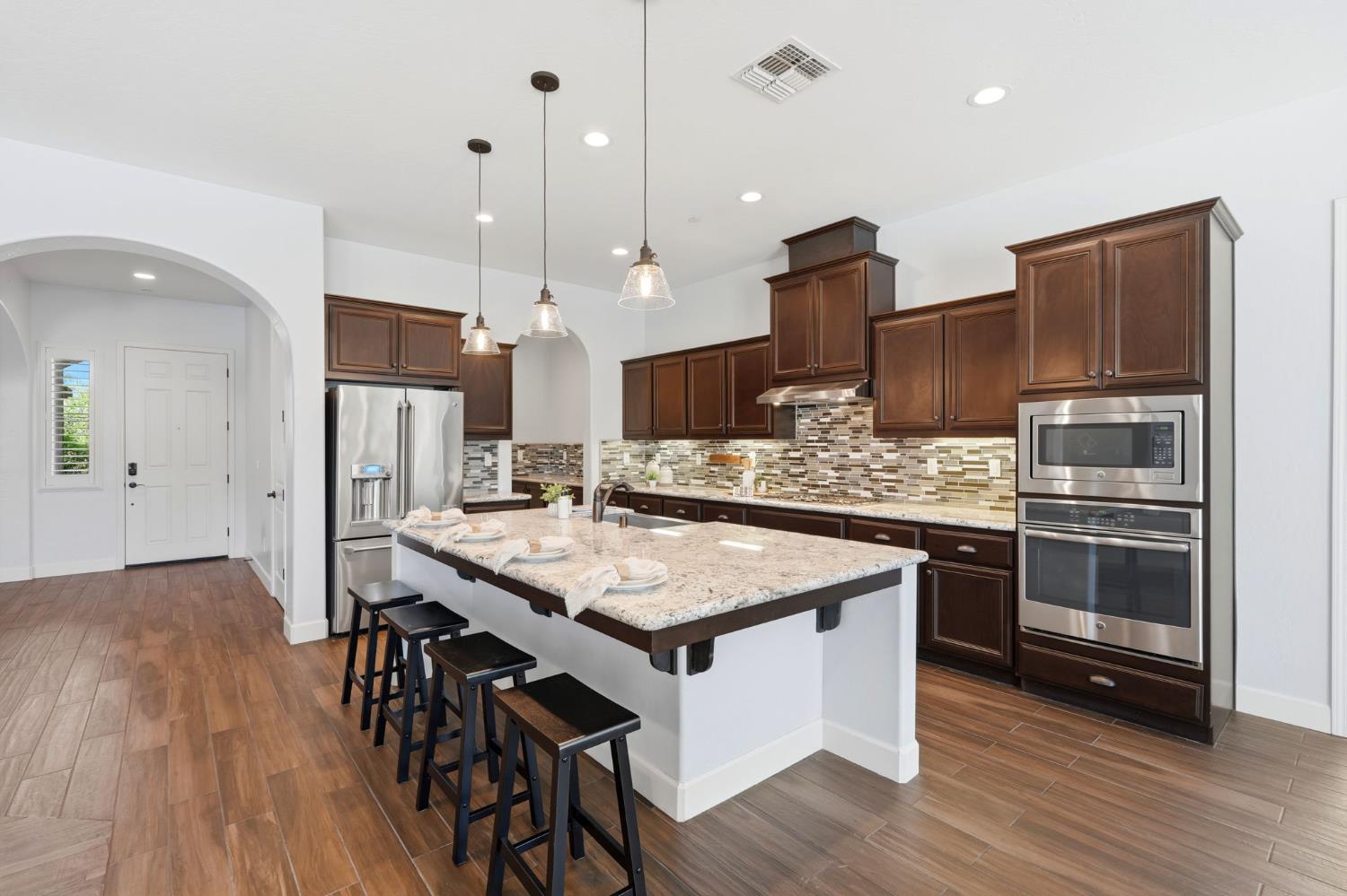 3368 North Discovery Way Hanford, CA 93230 - Photo 11 of 43 a kitchen with a table chairs stainless steel appliances and wooden floor