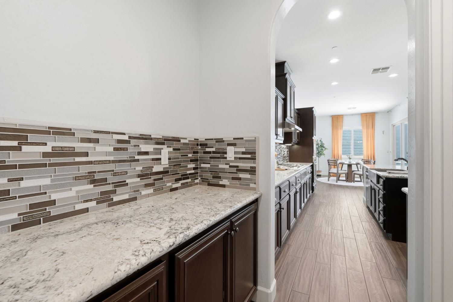 3368 North Discovery Way Hanford, CA 93230 - Photo 14 of 43 a kitchen with kitchen island a stove and a wooden floors