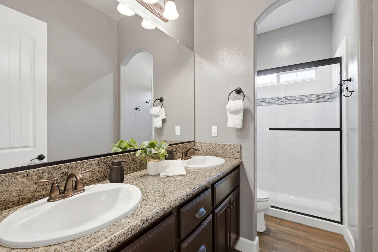 3368 North Discovery Way Hanford, CA 93230 - Photo 31 of 43 a bathroom with a granite countertop sink and a mirror