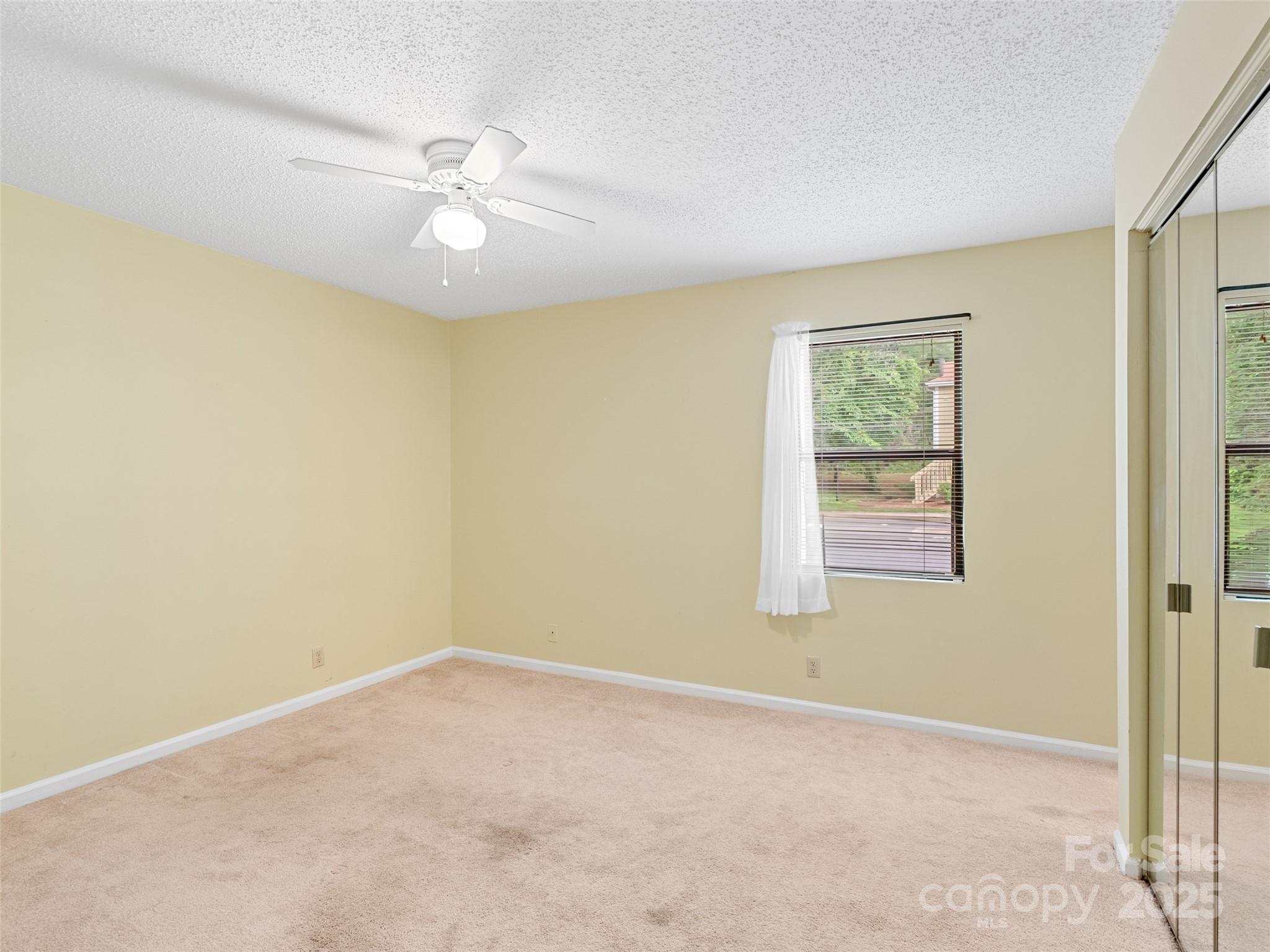 110 Heywood Road, Unit 17C Arden, NC 28704 - Photo 13 of 26 an empty room with a window and a fan