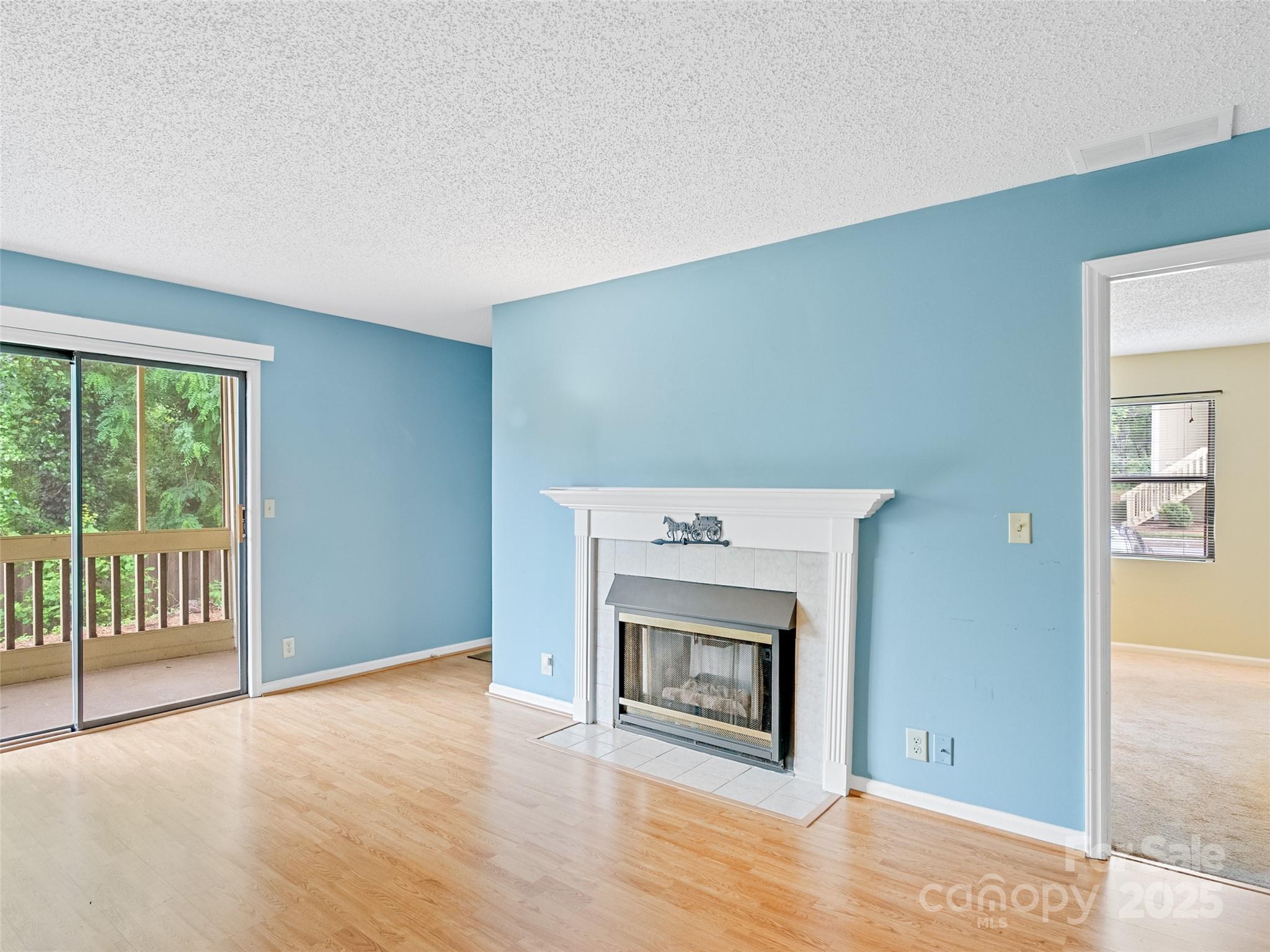 110 Heywood Road, Unit 17C Arden, NC 28704 - Photo 4 of 26 a view of an empty room with wooden floor and a fireplace