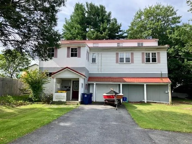 a view of a house with a small yard and a car parked in front of a house