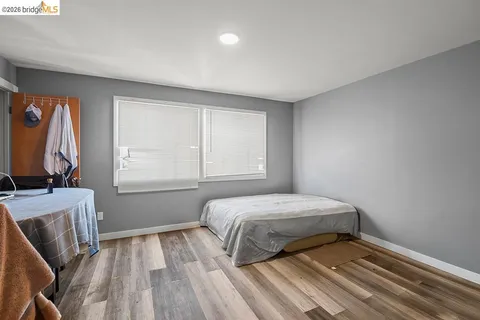 a bedroom with a bed and wooden floor