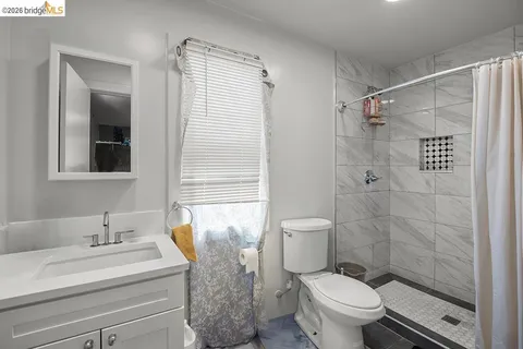 a bathroom with a granite countertop sink toilet and shower