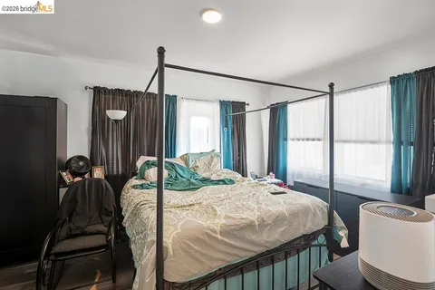 a bedroom with a bed window and a flat tv screen
