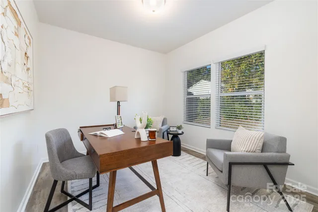 a view of a workspace with furniture and a window