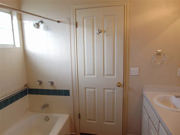 a bathroom with a tub a sink and a shower