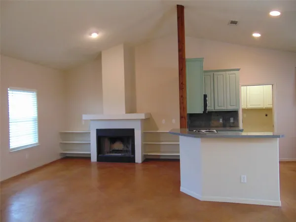 a living room with stainless steel appliances granite countertop furniture and a fireplace