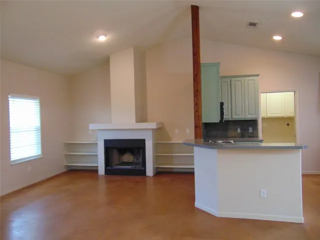 a living room with stainless steel appliances granite countertop furniture and a fireplace