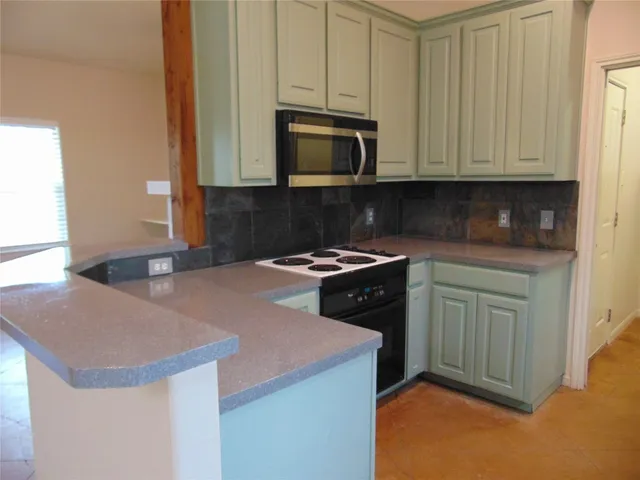a kitchen with a sink and a stove top oven with wooden floor