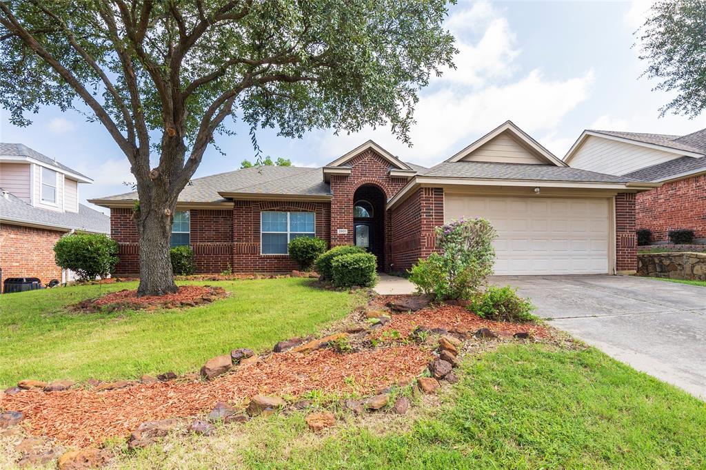 Ranch-style home with roof with shingles, concrete driveway, a front yard, a garage, and brick siding