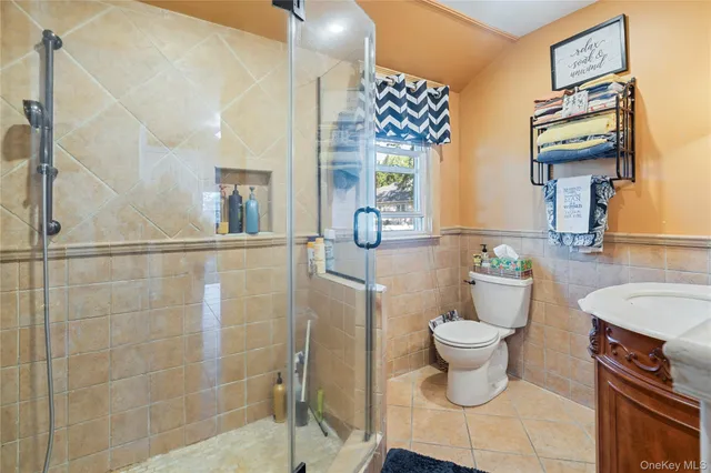 a bathroom with a granite countertop sink a toilet a mirror and shower