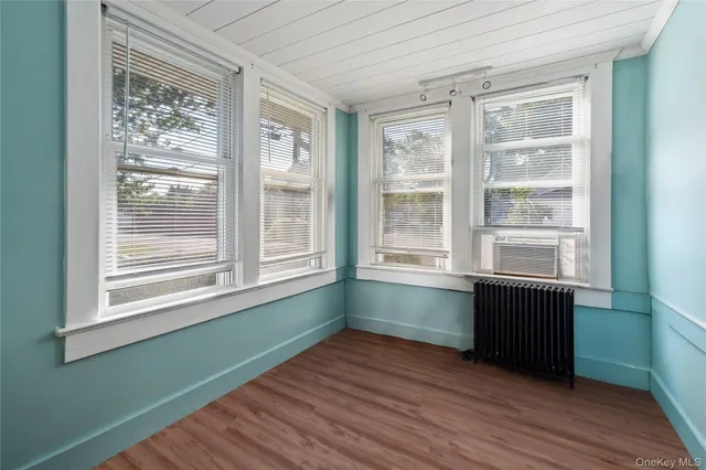 a room with wooden floor and windows