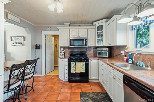 a kitchen with stainless steel appliances granite countertop a stove top oven a sink dishwasher and a refrigerator with wooden floor