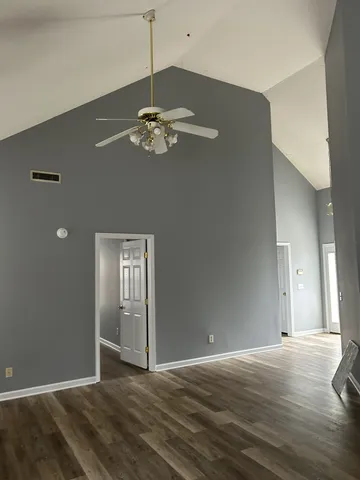 a view of empty room with window and ceiling fan