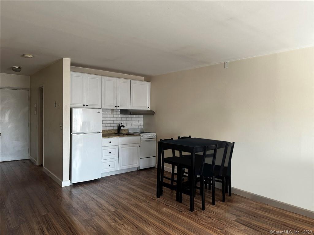 7 Winfield Street, Unit 2 Norwalk, CT 06855 - Photo 3 of 10 a kitchen with stainless steel appliances a dining table chairs and wooden floor