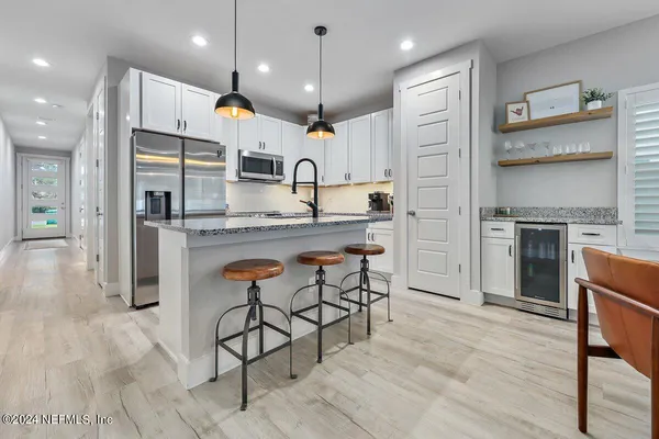 a kitchen with stainless steel appliances kitchen island granite countertop a sink refrigerator and cabinets