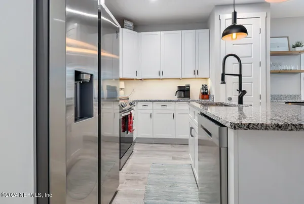 a kitchen with stainless steel appliances granite countertop a sink a stove and cabinets