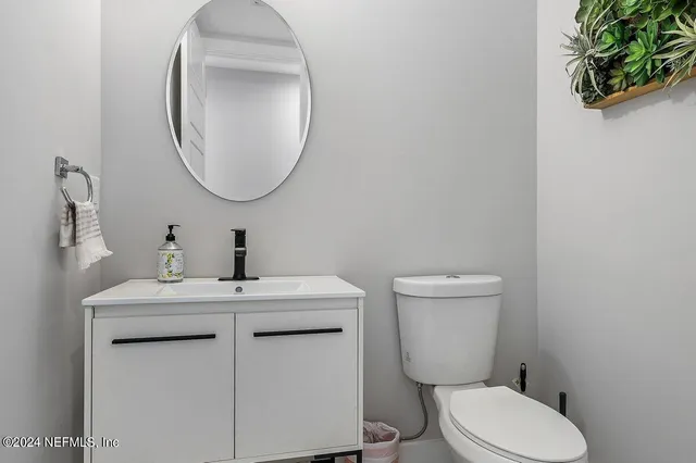 a bathroom with a toilet a sink and a mirror