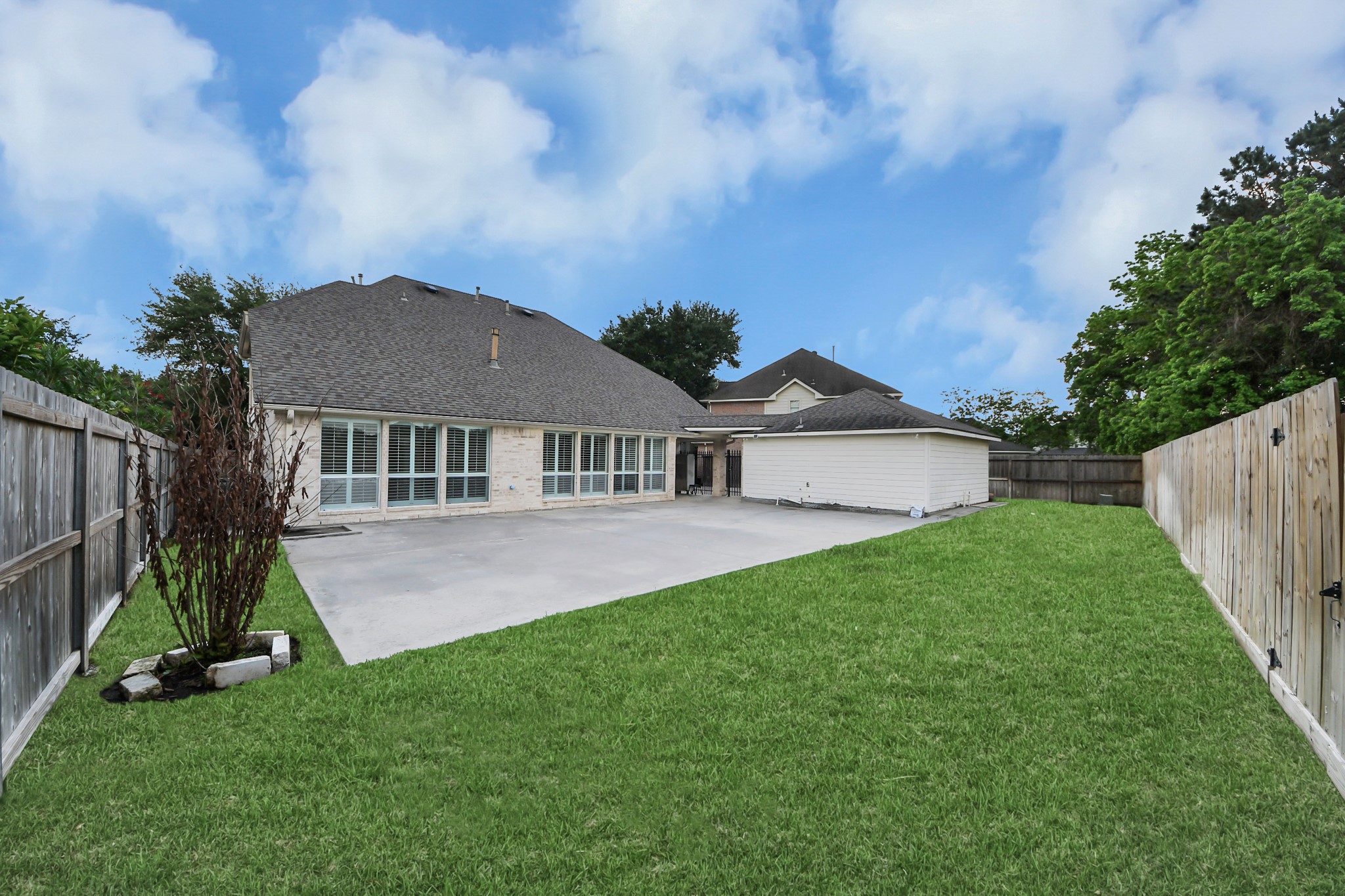 20111 Biscayne Hill Court Spring, TX 77379 - Photo 38 of 44 Spacious backyard featuring a large concrete patio, perfect for outdoor gatherings, and a well-maintained lawn, all enclosed by a wooden privacy fence.