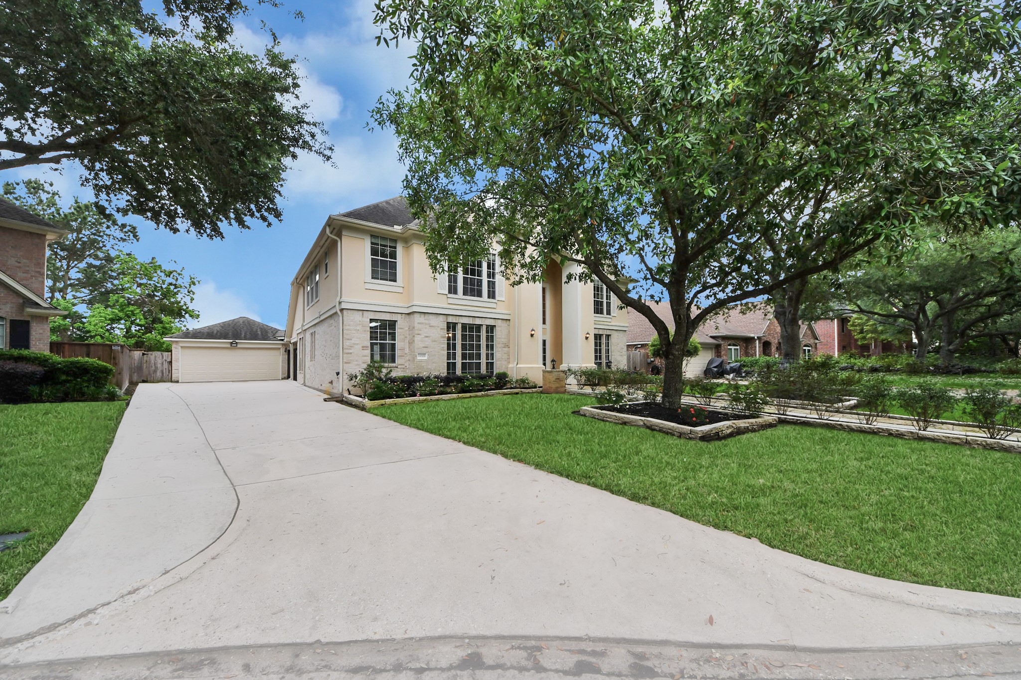 20111 Biscayne Hill Court Spring, TX 77379 - Photo 4 of 44 Charming two-story home with a spacious driveway leading to a detached garage. The front yard is beautifully landscaped with mature trees and lush greenery, offering great curb appeal.