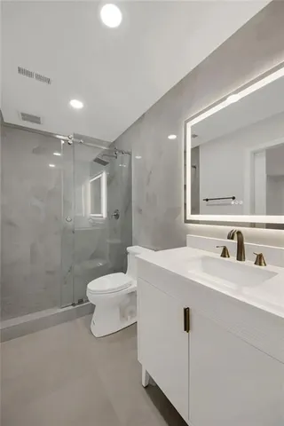 a bathroom with a sink a toilet and shower