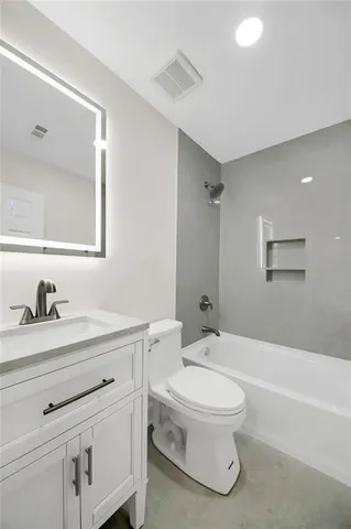 a bathroom with a toilet a sink a mirror and a bathtub
