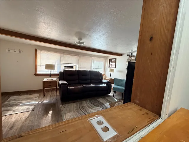 a living room with furniture a large window and a flat screen tv