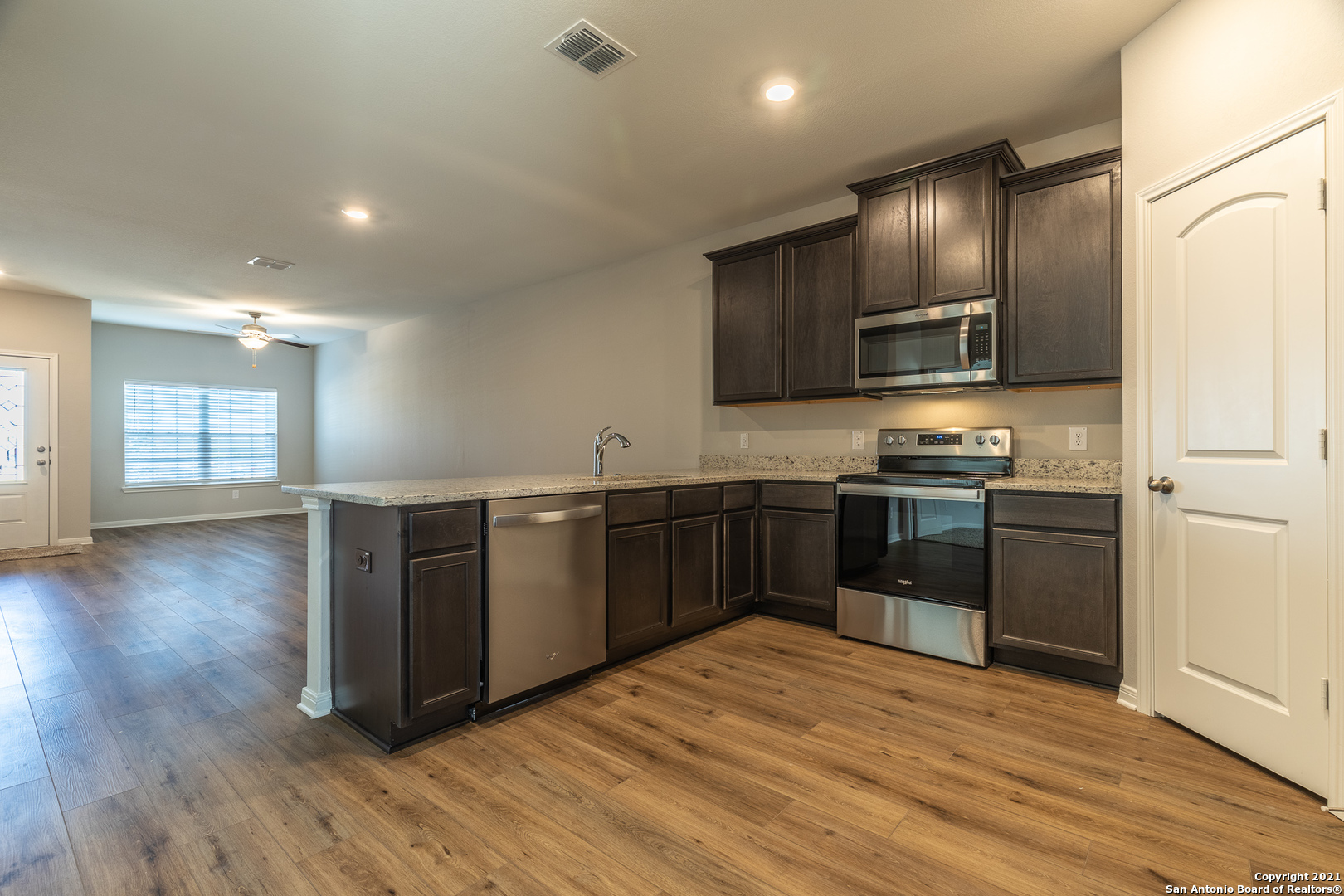 9338 Espadrille Run Converse, TX 78109 - Photo 14 of 46 a kitchen with stainless steel appliances kitchen island granite countertop a stove a sink and a refrigerator