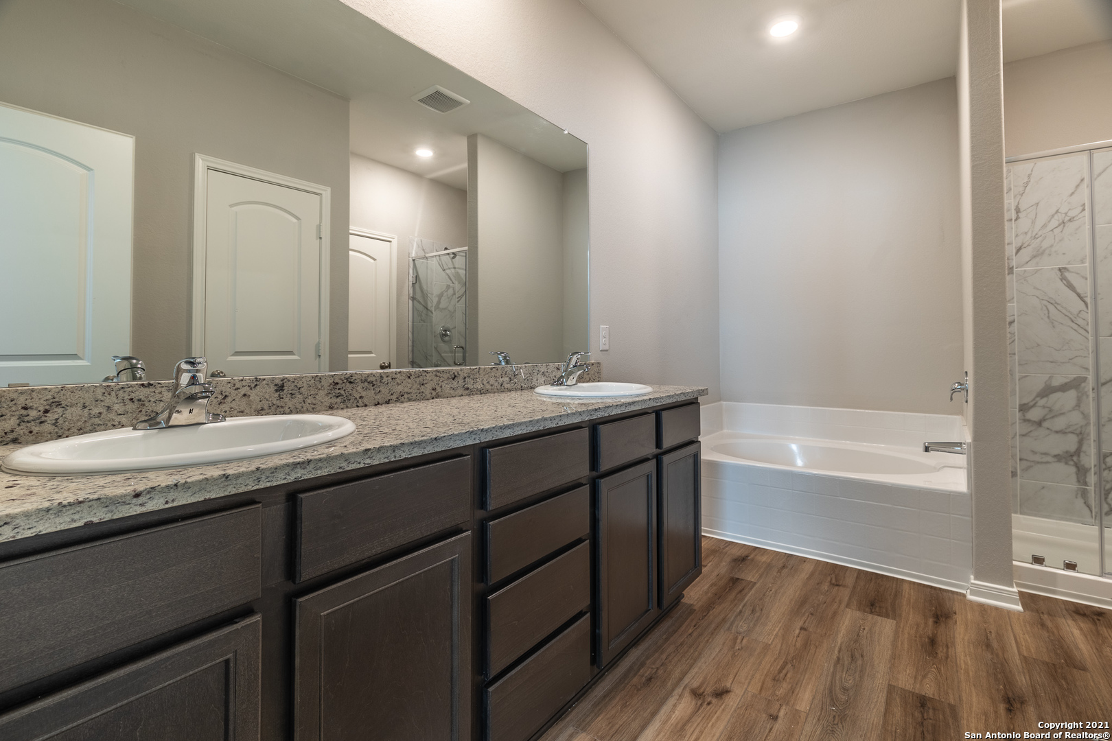9338 Espadrille Run Converse, TX 78109 - Photo 20 of 46 a bathroom with a double vanity sink a mirror and a bathtub